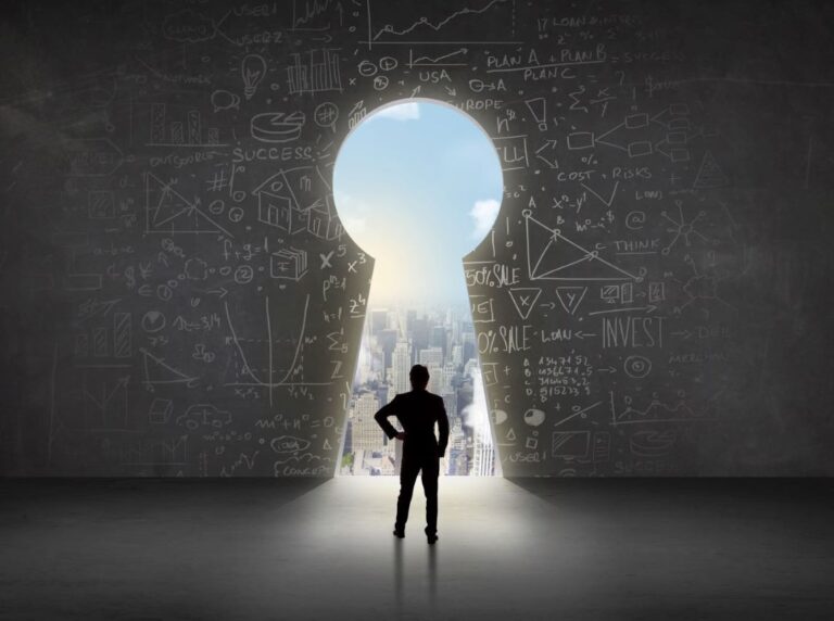Businessman stands in front of large keyhole opening in a wall with data analytics written on it.