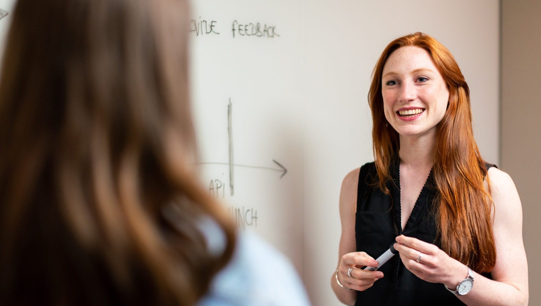 Young businesswoman discusses different marketing research tools with a colleague.